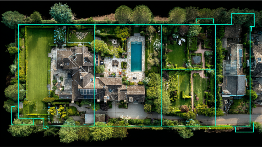 Aerial top-down view of a large residential property with pool, patio, and gardens outlined by digital parcel boundary lines.